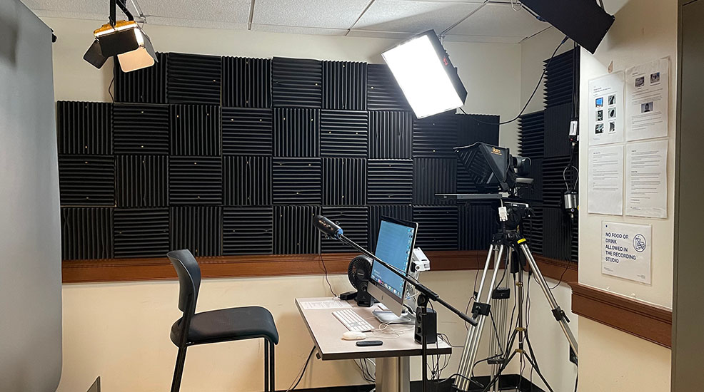 A photograph showing the layout of our DIY recording studio. The studio is equipped with lighting, backdrop, 4K camera, and a computer that are already set up for users to use.